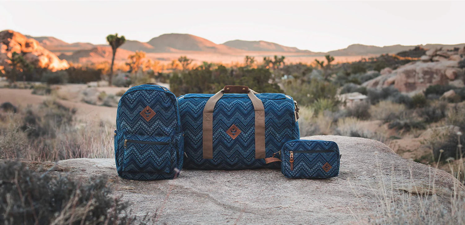 Trois sacs bleus posés sur un rocher au cœur de la nature