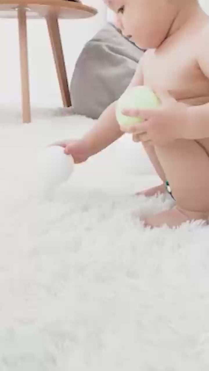 Bébé qui marche dans la maison avec une couche réutilisable vert orange